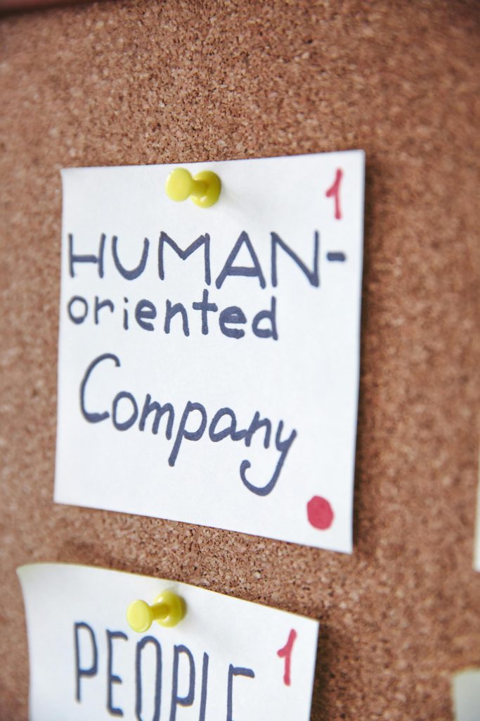 Handwritten notes on a corkboard illustrating a human-oriented company concept.